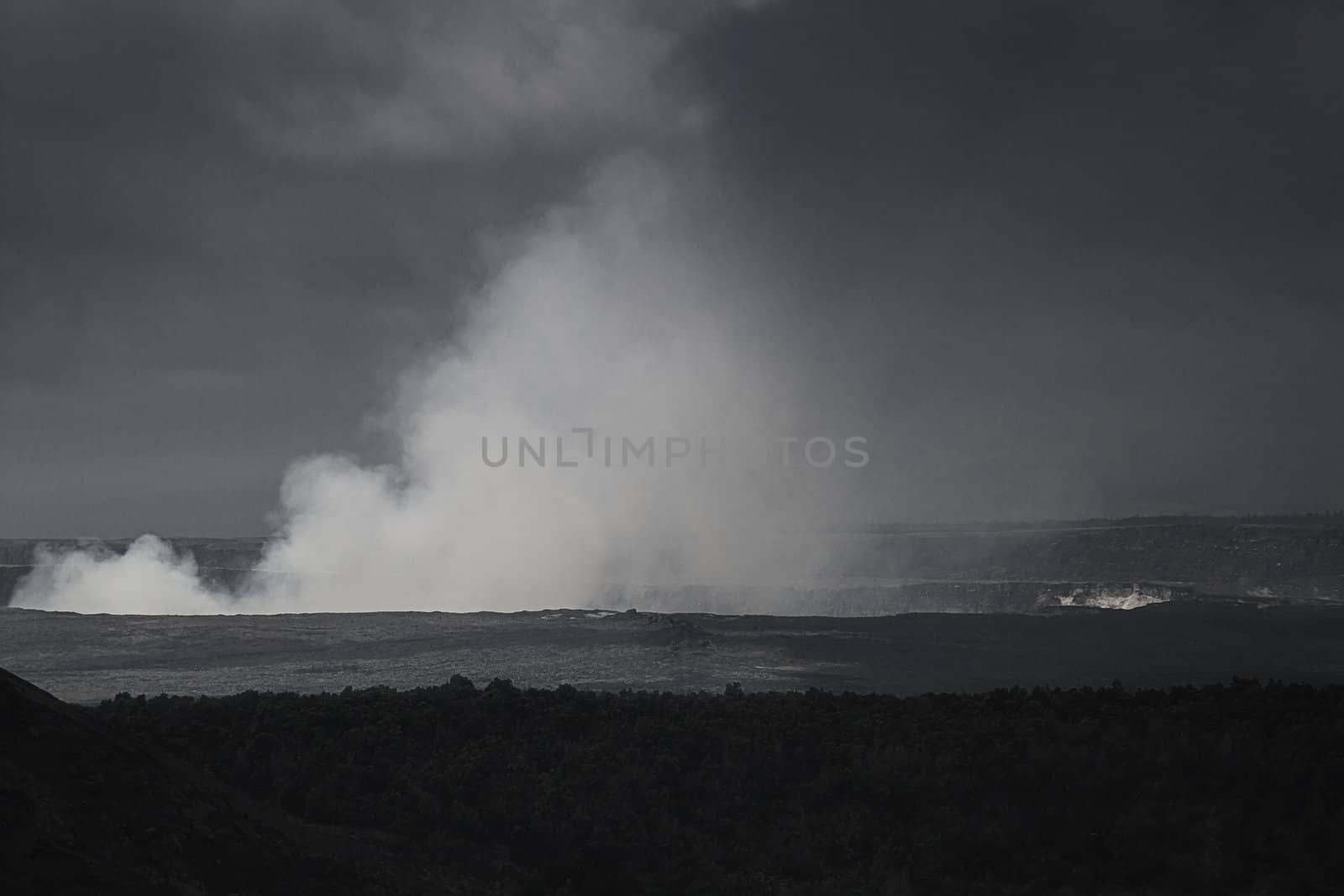 Steaming hole of the kilauea volcano during a cloudy day in black and white