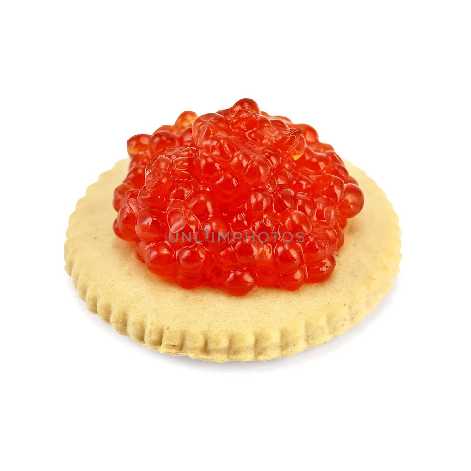 Red salmon caviar on a round cracker isolated on white background