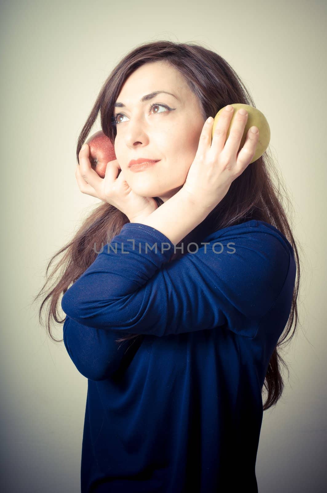 beautiful woman with red and yellow apples on gray background