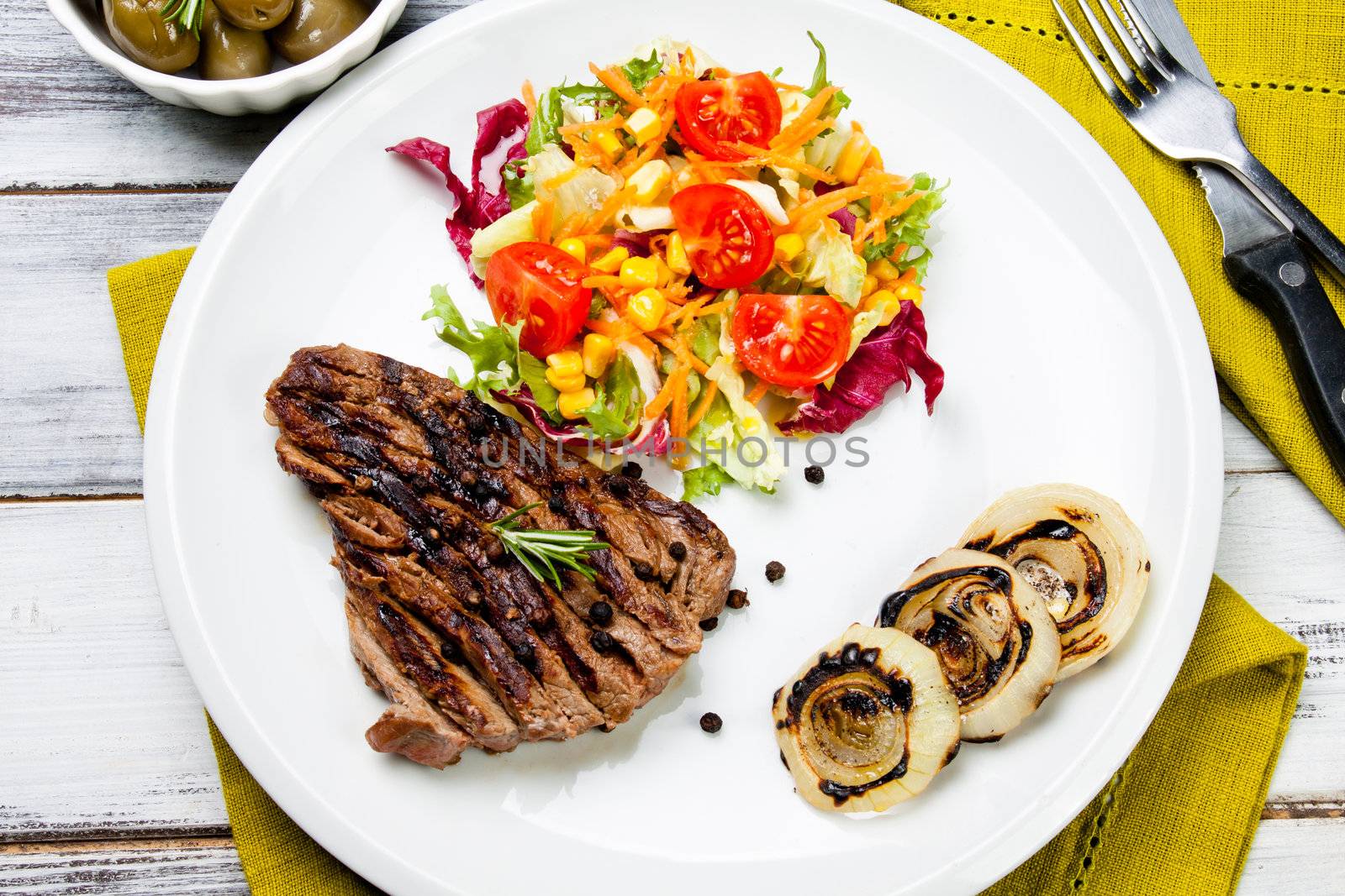 cooked cut of meat garnish with mixed salad