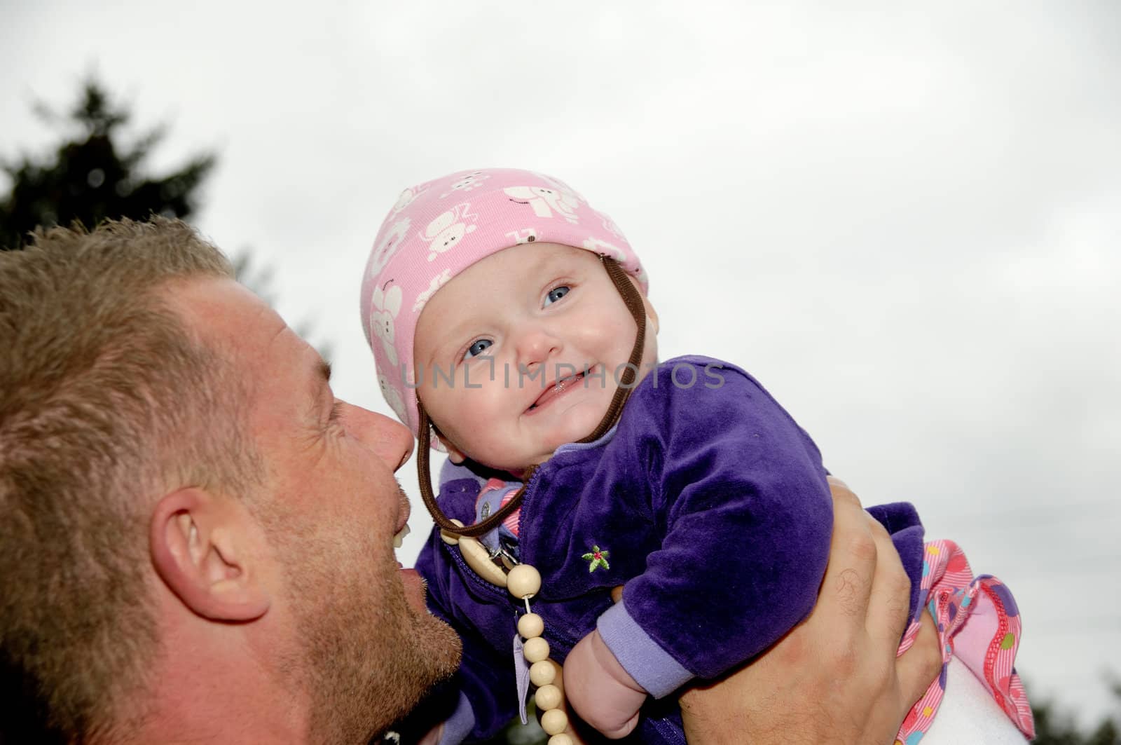 Happy father is lifting up his smiling baby
