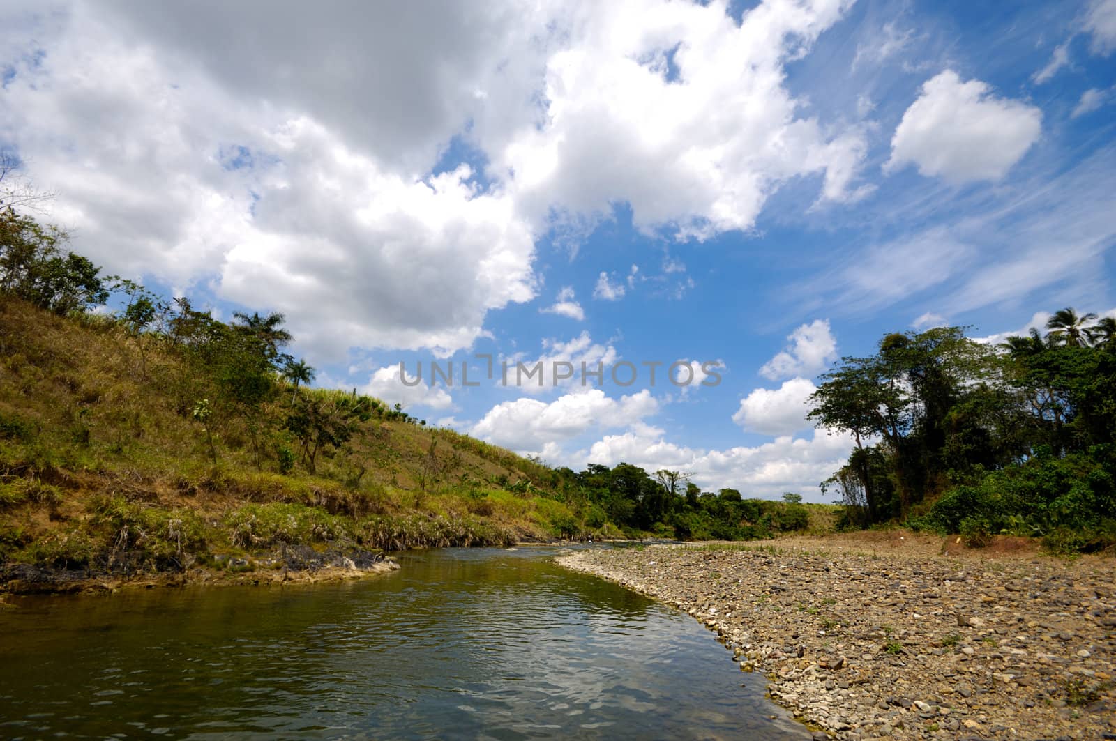 River and green nature with white clouds. Dominican Republic.