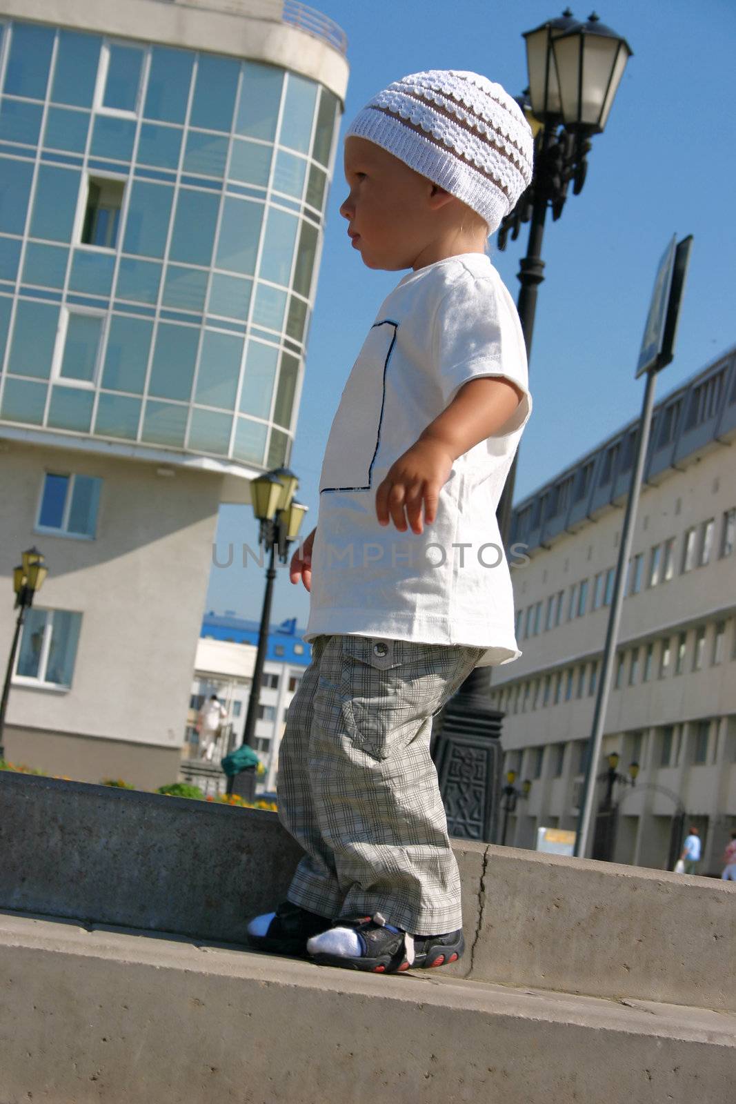 little boy in casual clothes on a walk by a sun summer day