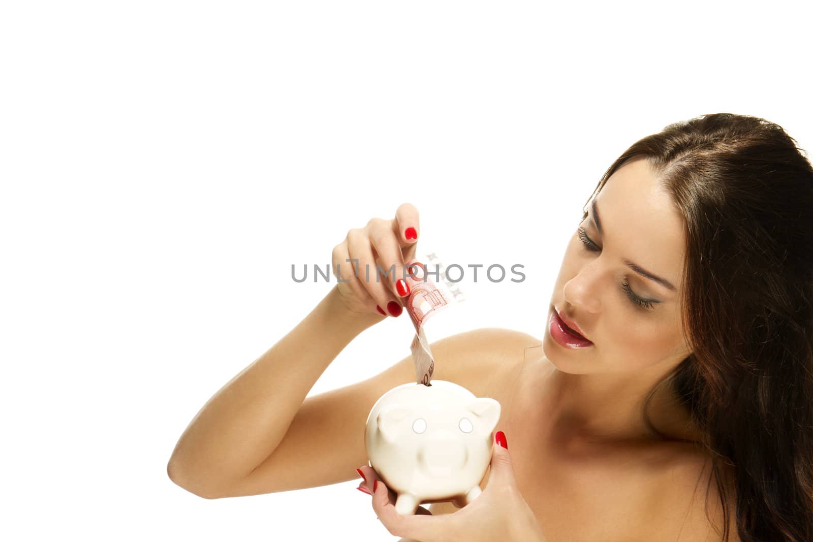 beautiful woman put some money in her piggy bank on white background