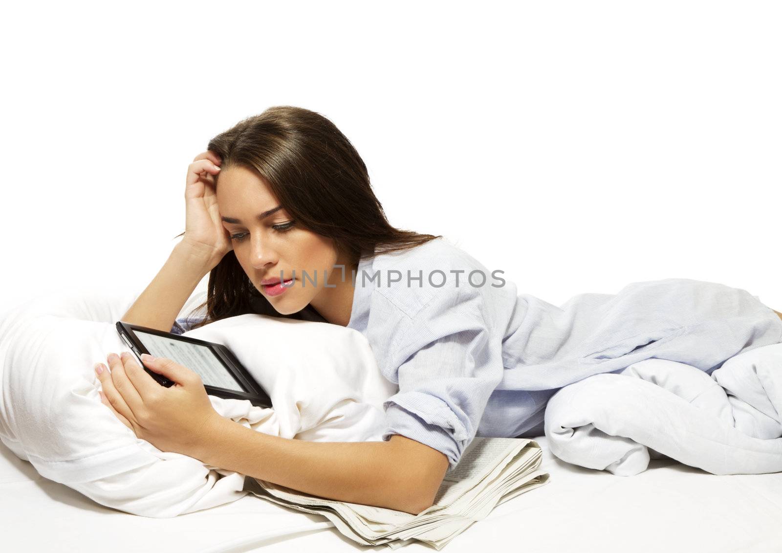 beautiful woman in bed reading ebook on white background