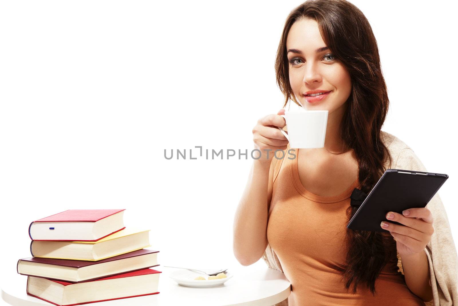 smiling woman with ebook reader, coffee at a table with books on white background