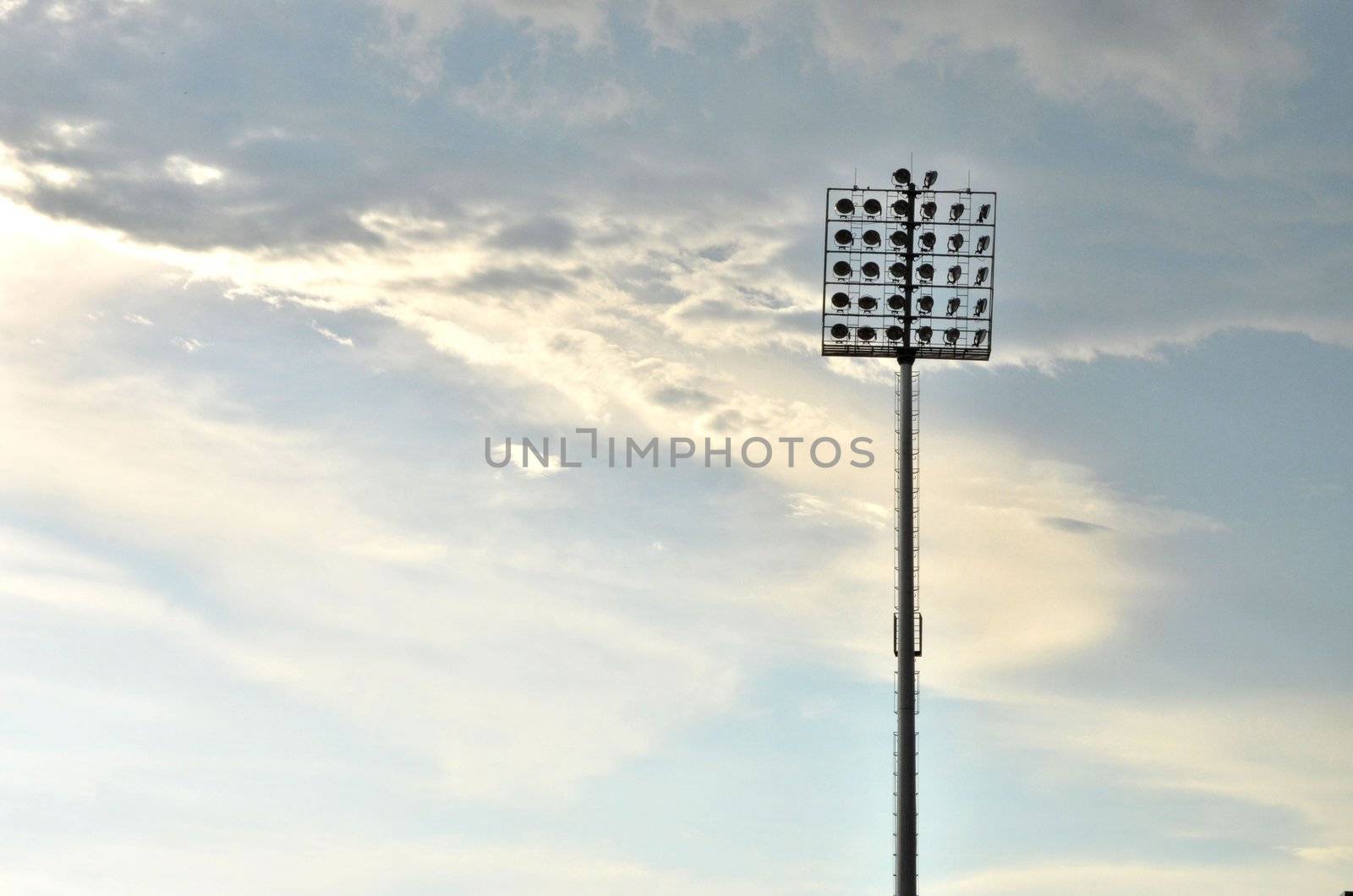 Sport light tower for arena with cloudy sky background