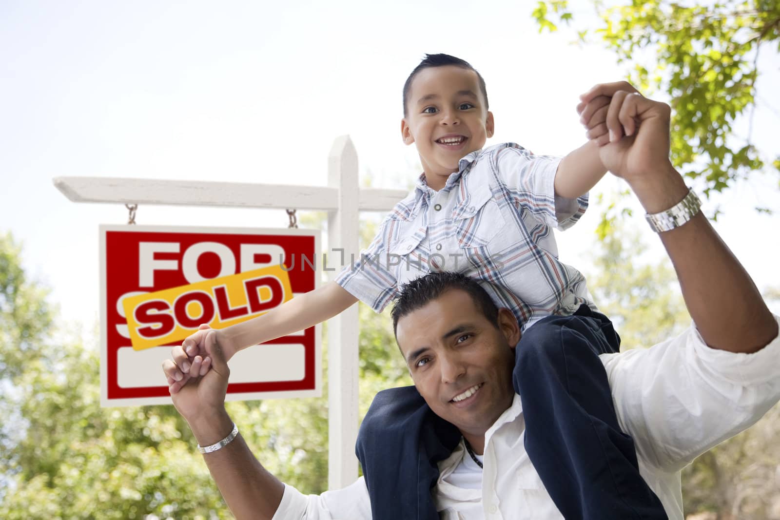 Hispanic Father and Son with Sold Real Estate Sign by Feverpitched