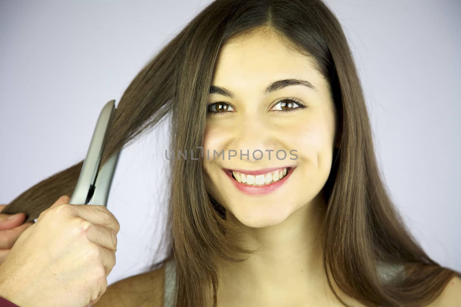 Girl gets her hair ironed smiling