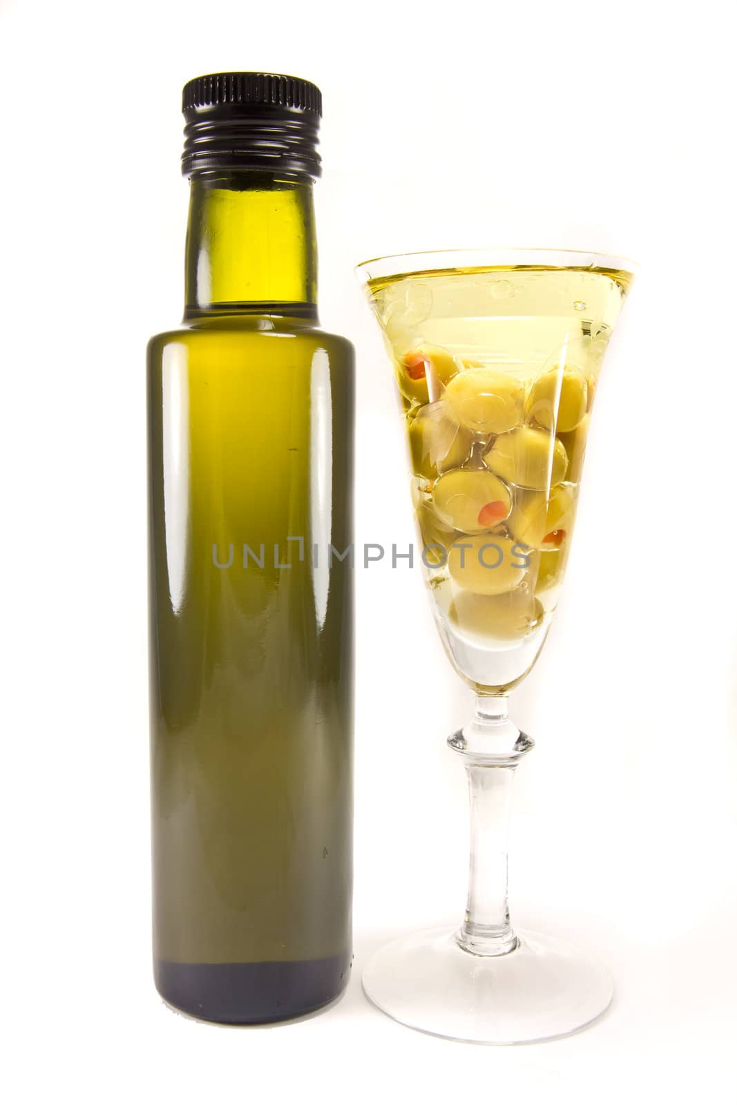 Picture of a bottle of olive oil and olives in a wine glass