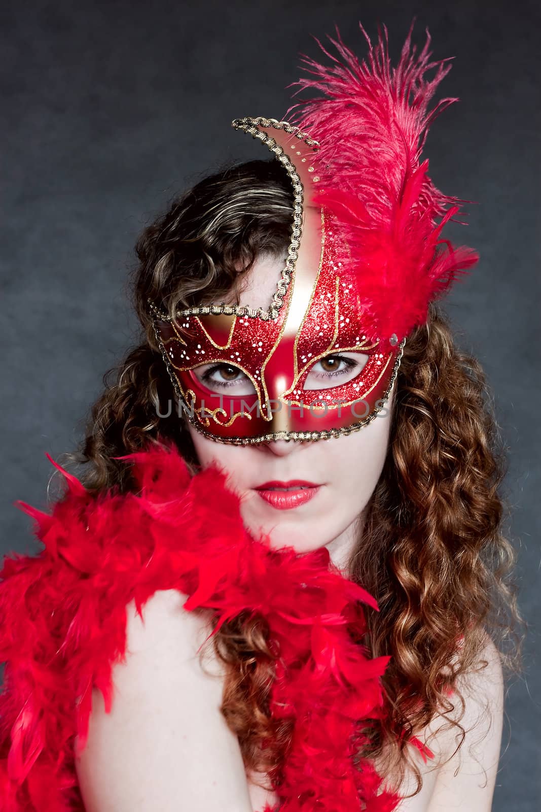 Beautiful young lady in a red venetian mask