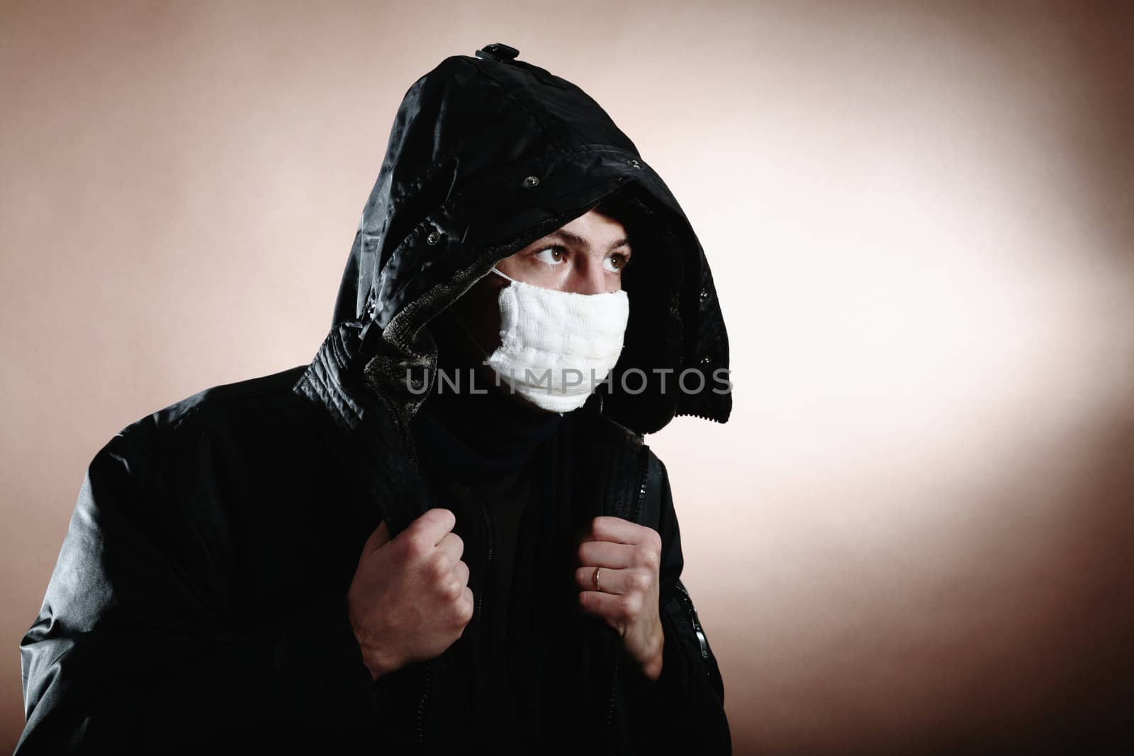 A young man with a protective mask on brown background