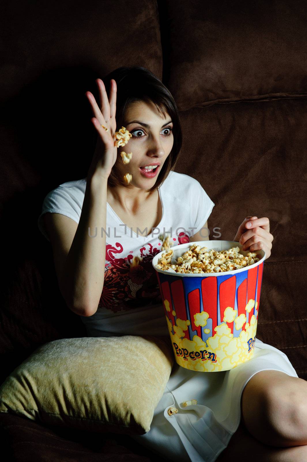 An image of woman watching TV with popcorn