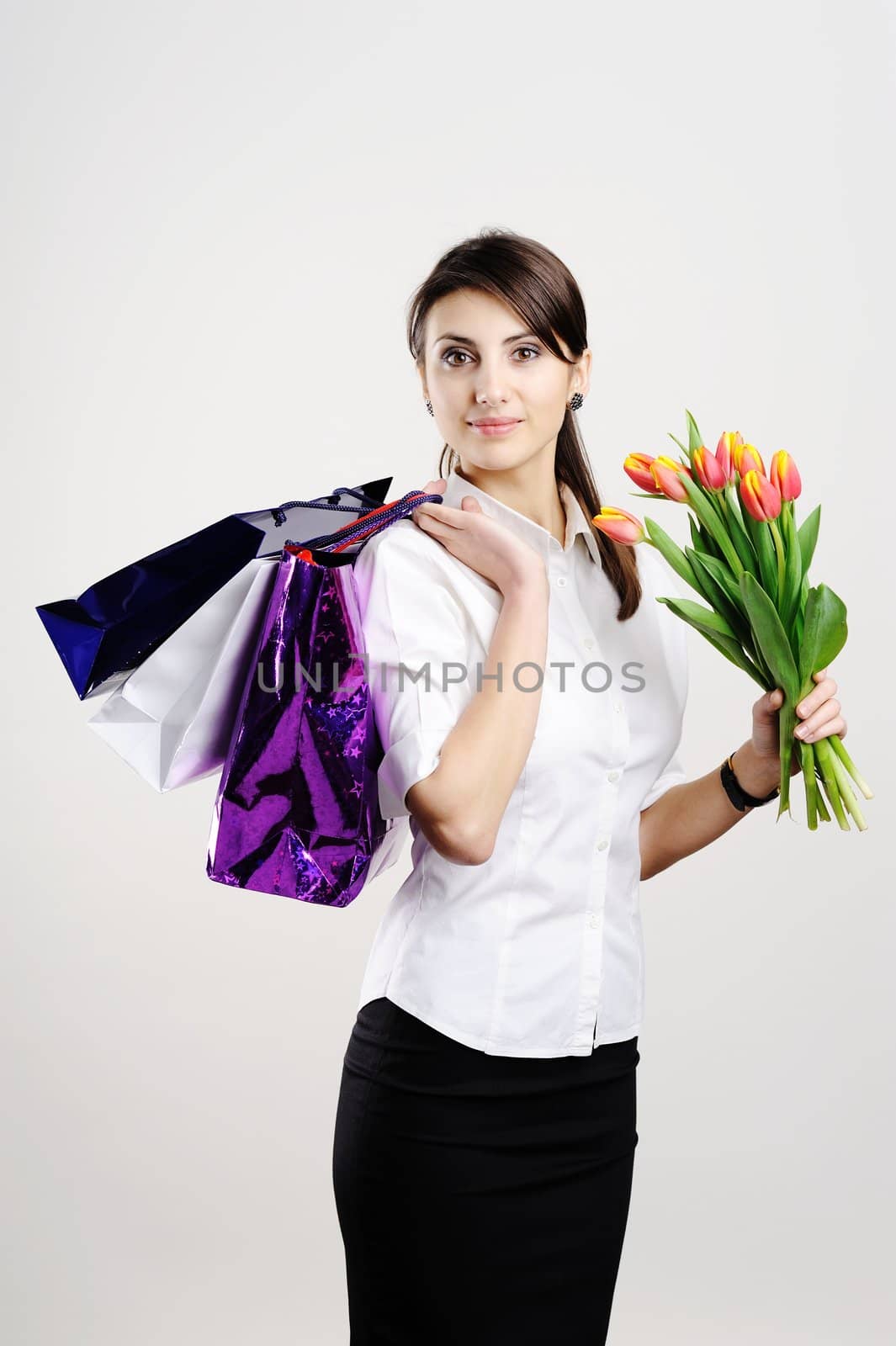 An image of young woman with tulips and with bags