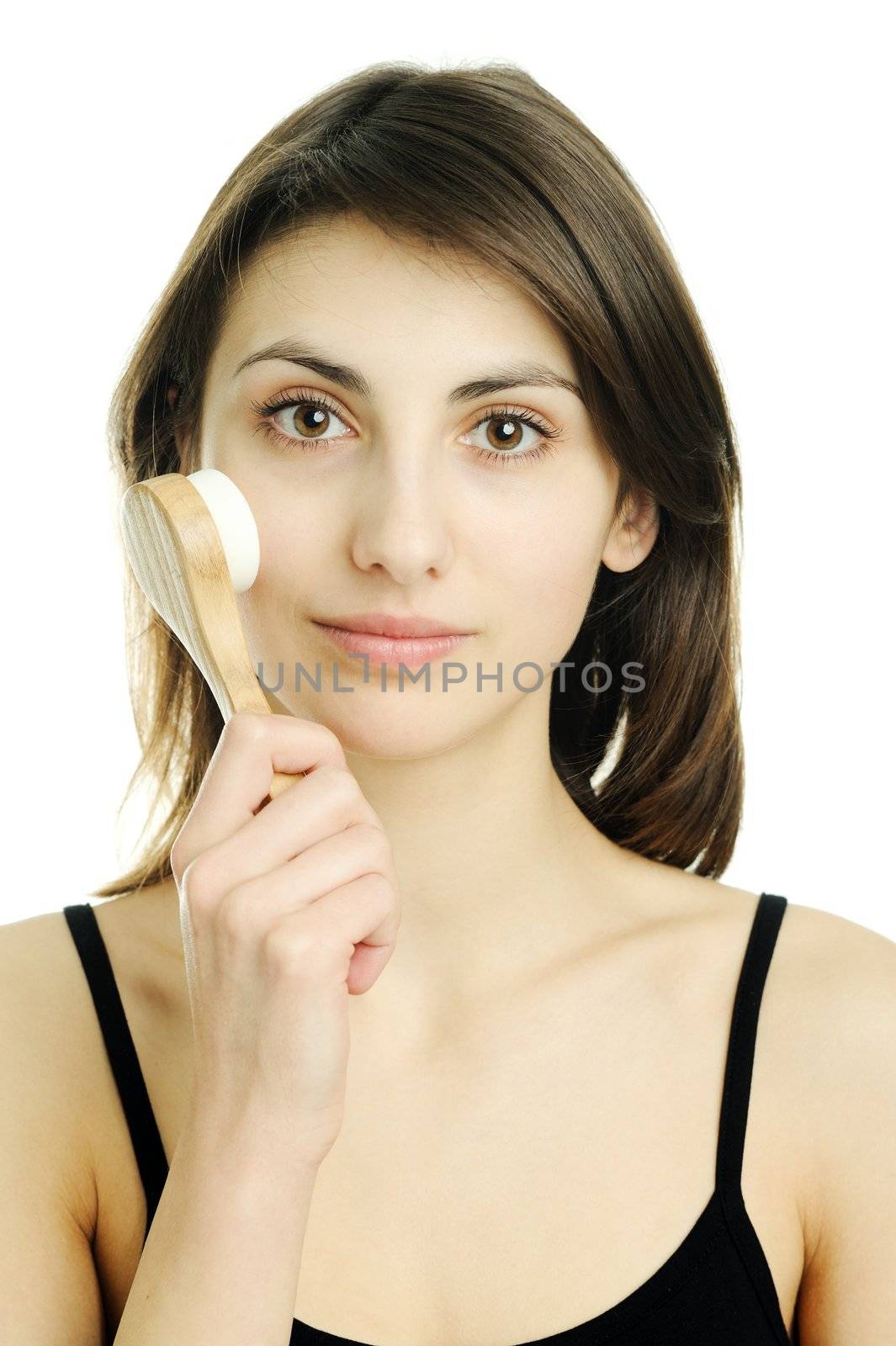 An image of a young woman cleaning her face