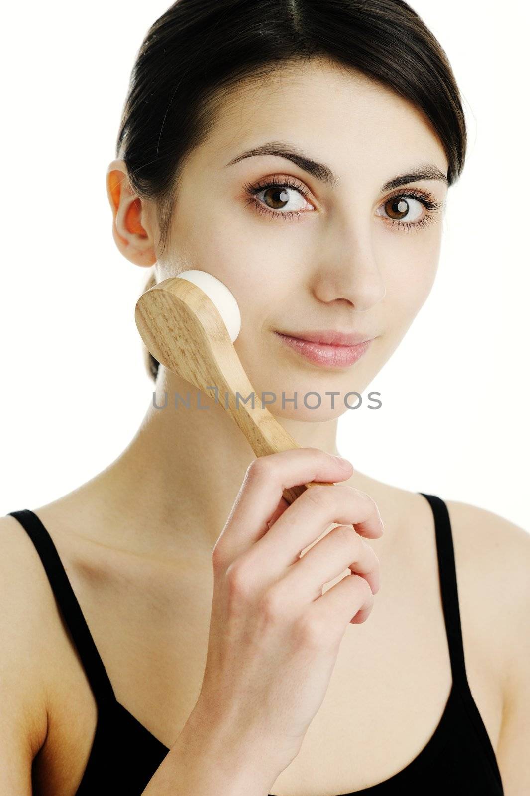 An image of a young woman cleaning her face