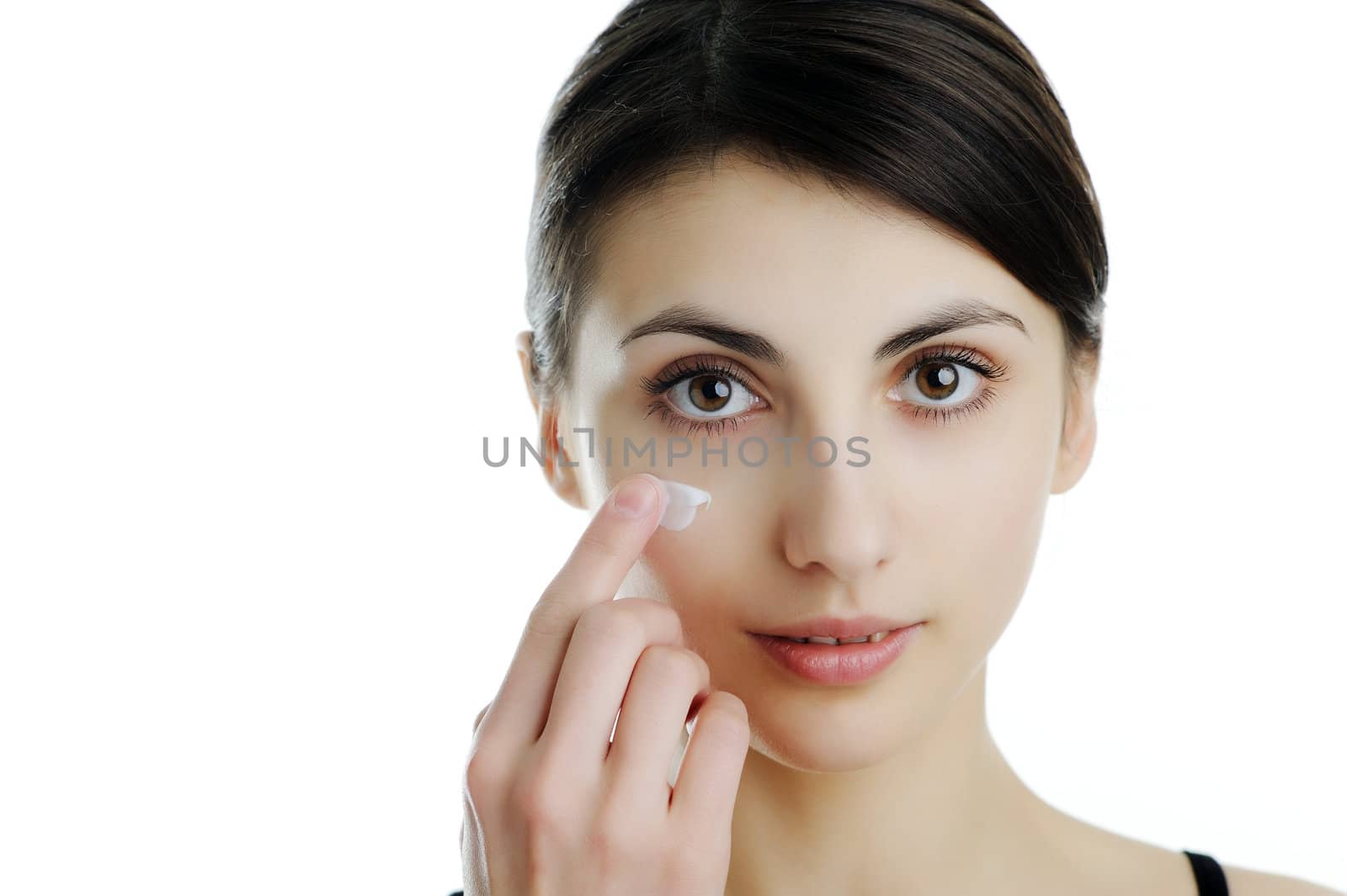 An image of a girl putting some cream onto her face