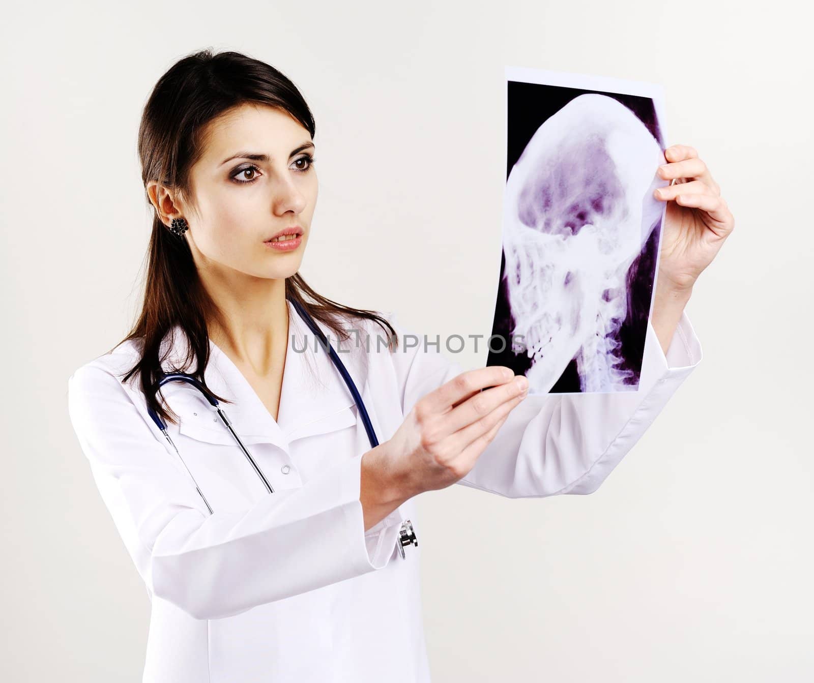 An image of female doctor examing x-ray of scull