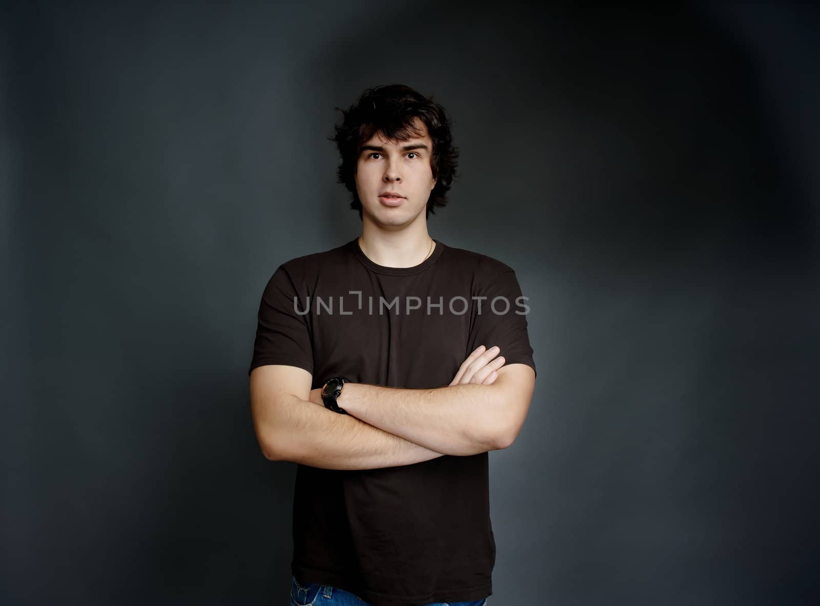 An image of a young man with arms on his chest