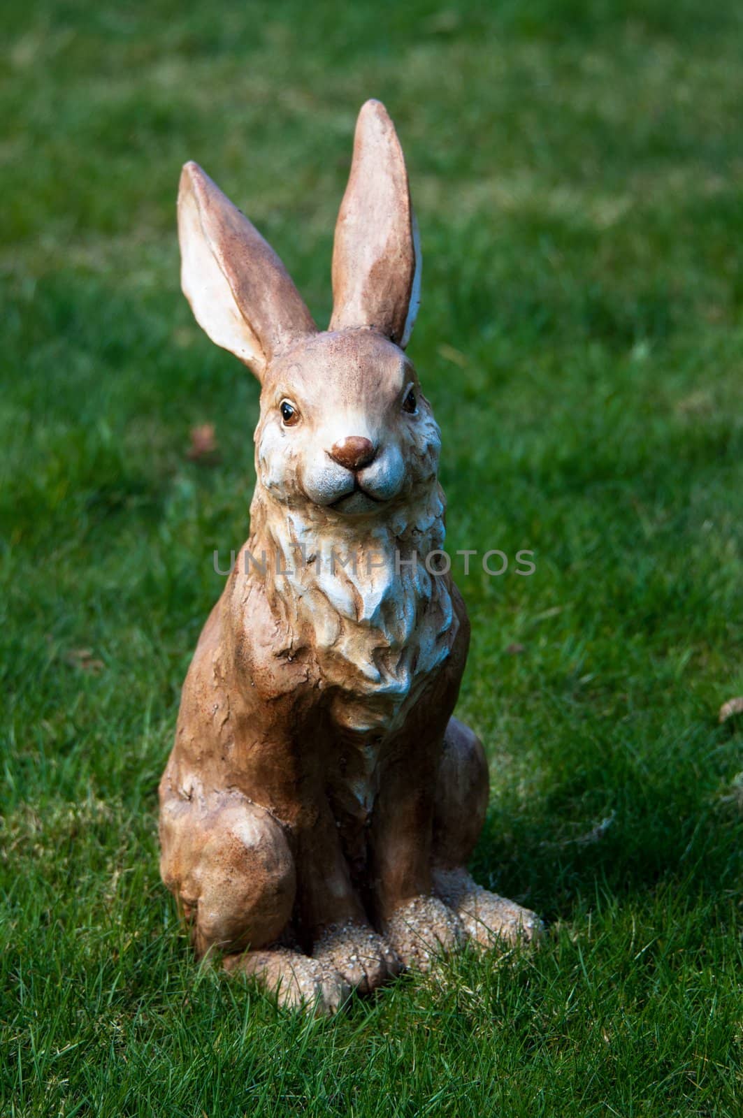 Easter decoration: Clay rabbit sitting in grass field