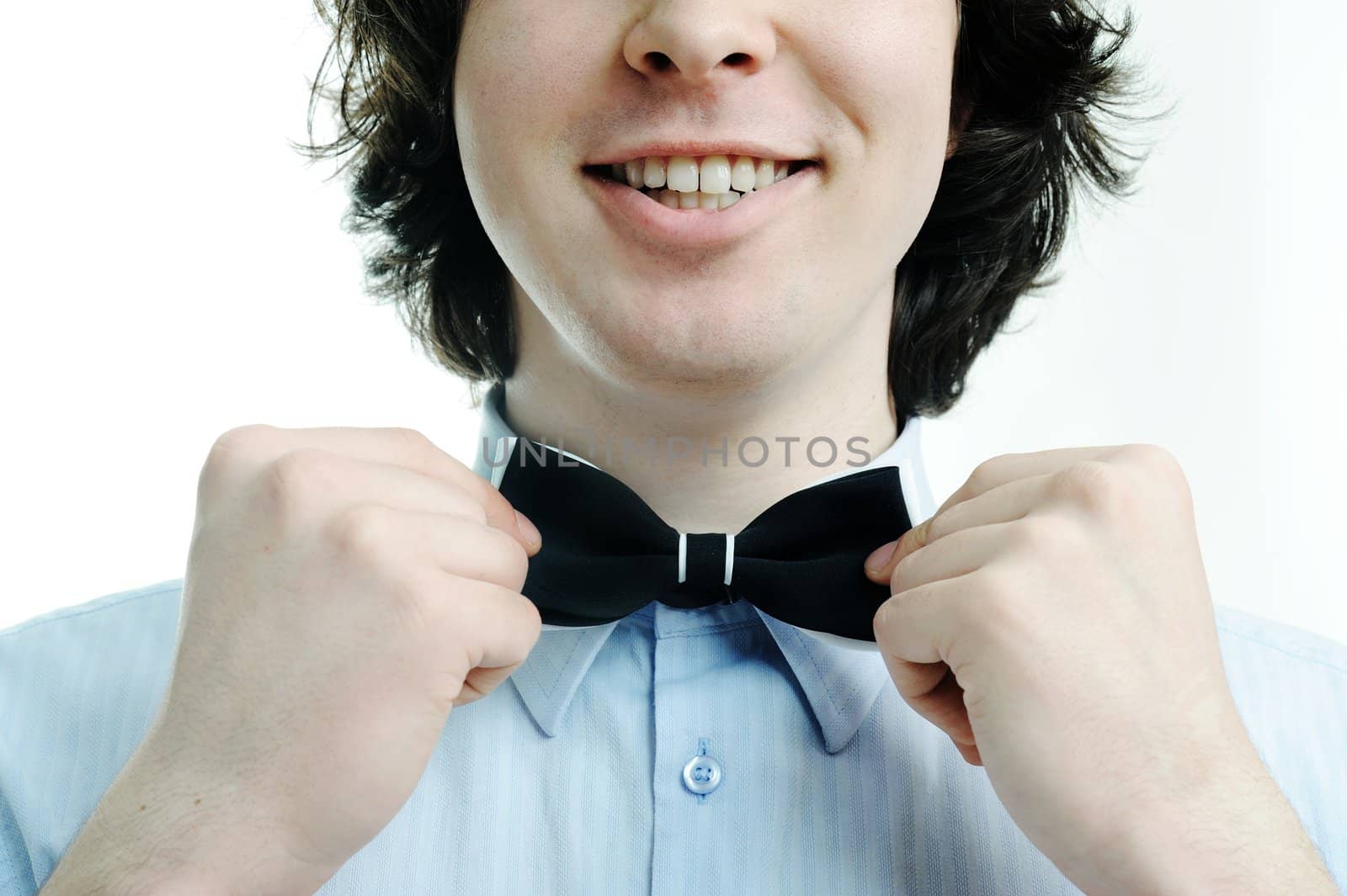 An image of a young waiter touching his tie