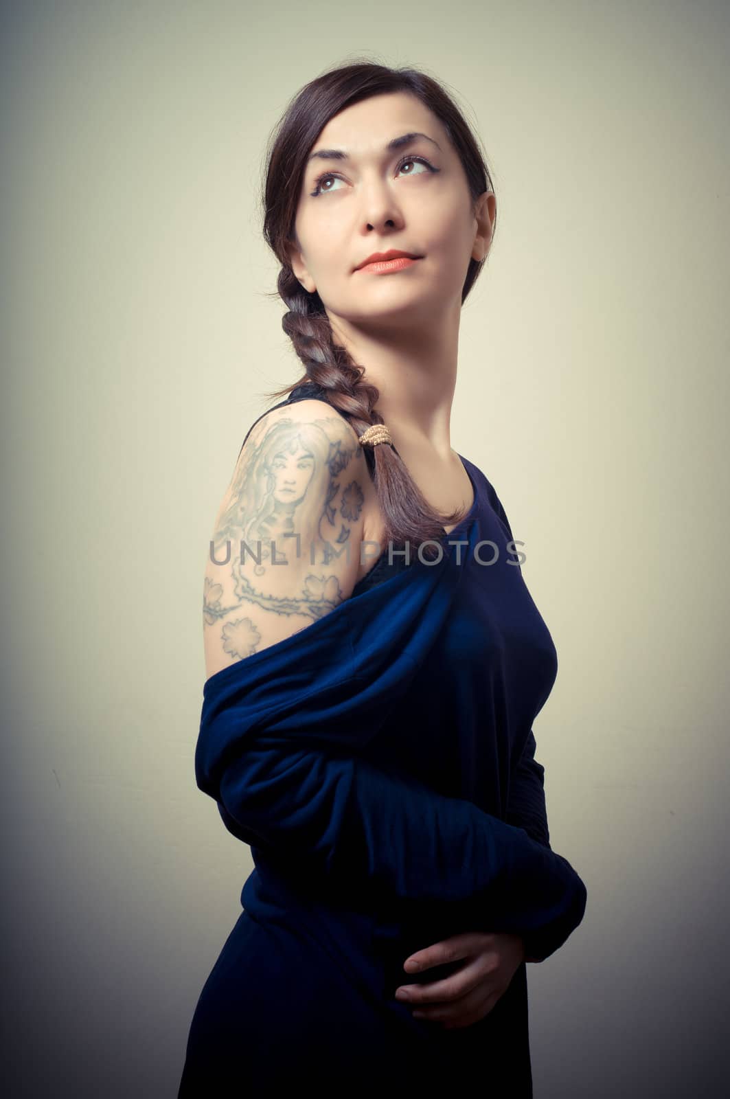 portrait of beautiful girl with long hair and blue sweater on gray background