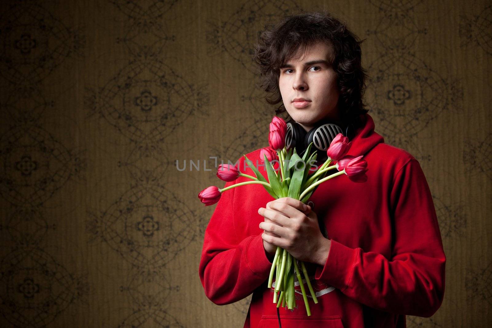 A young man with a bunch of red tulips