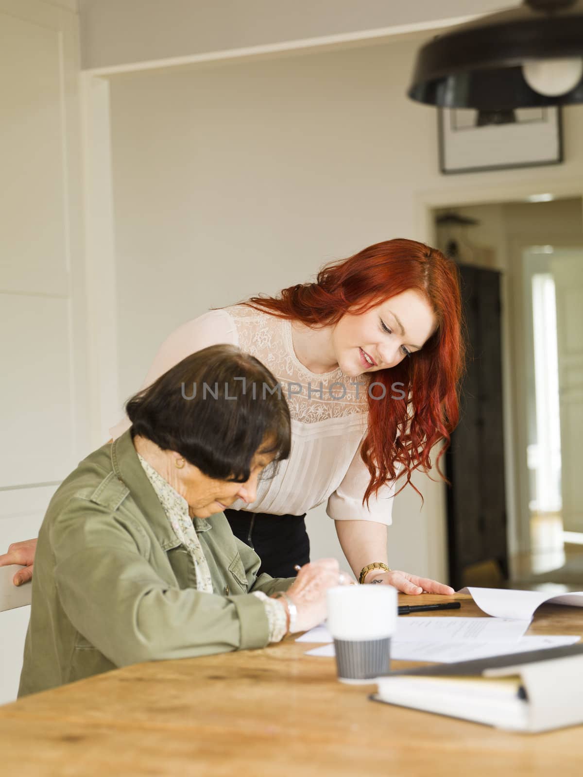 Young woman helping her Grandmother with paperwork