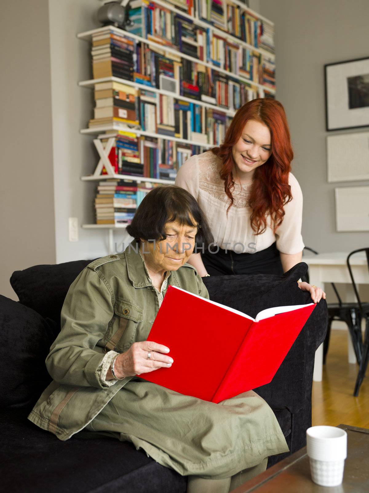 Young woman and her Grandmother looking in the Photo Album