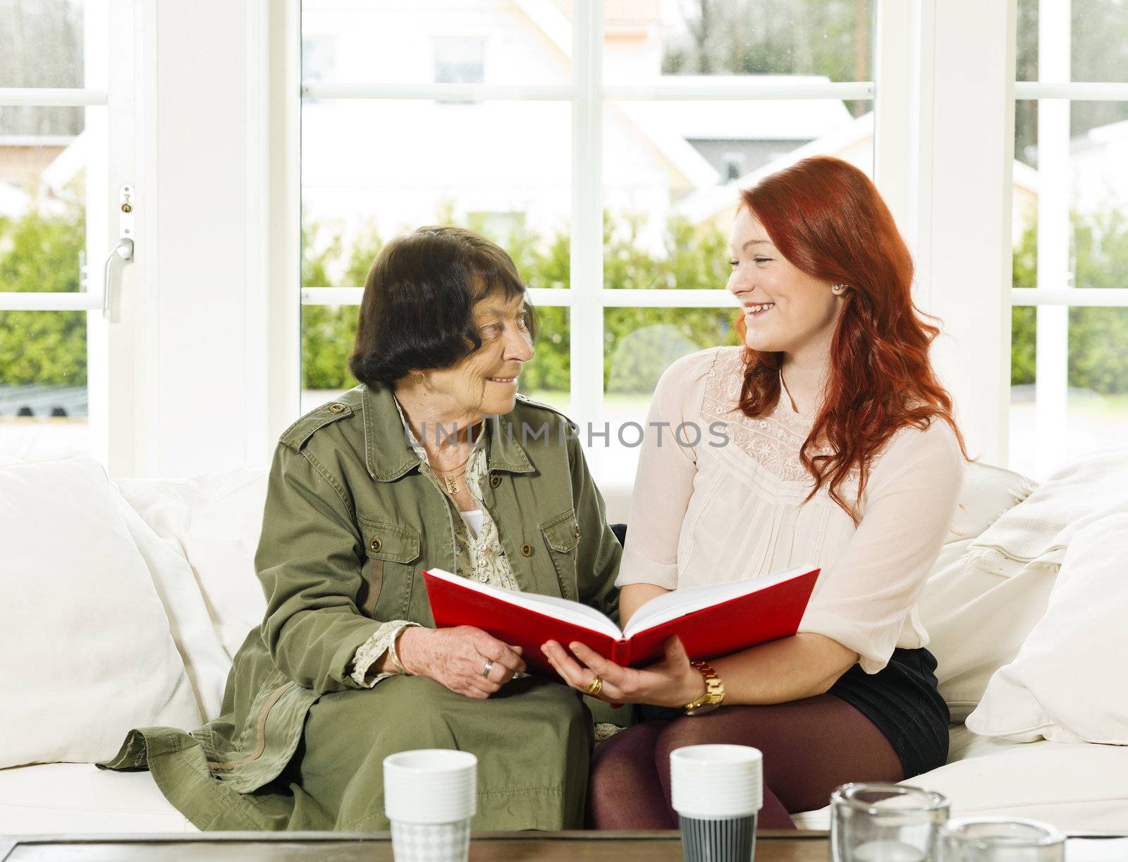 Young woman and her Grandmother looking in the Photo Album