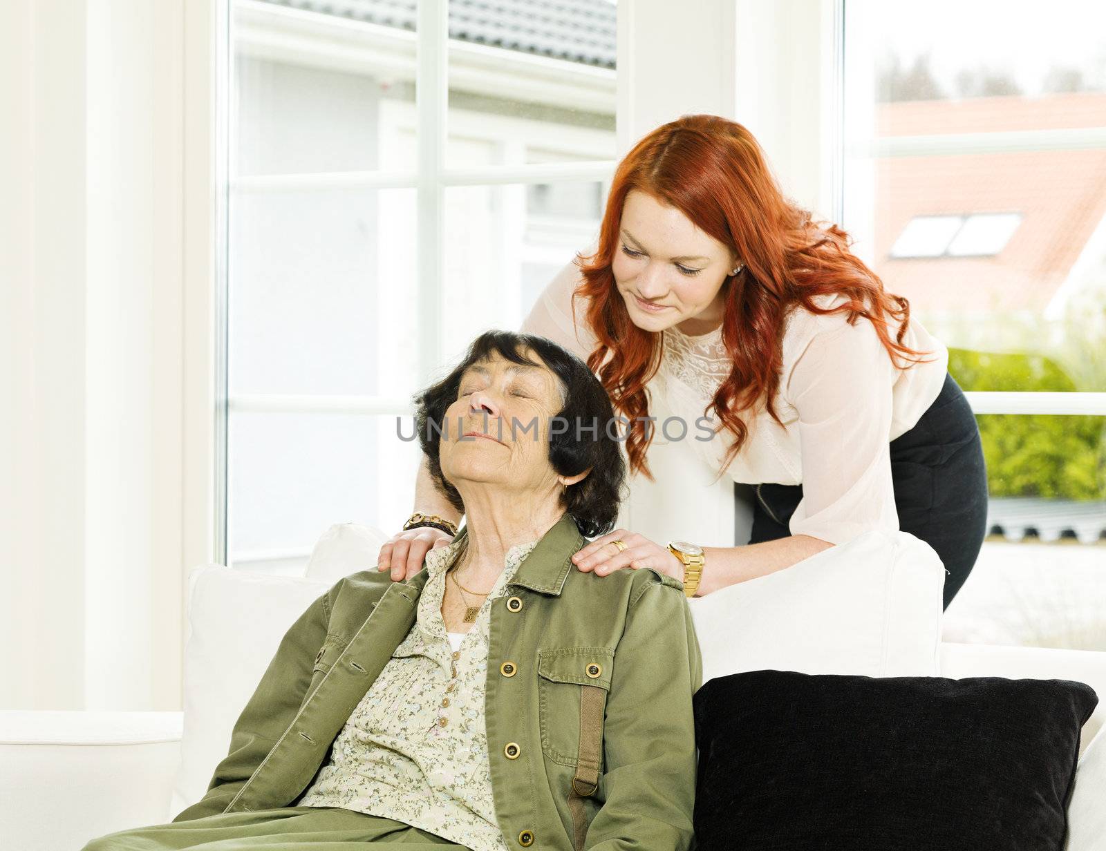 Young woman giving massage to her Grandmother