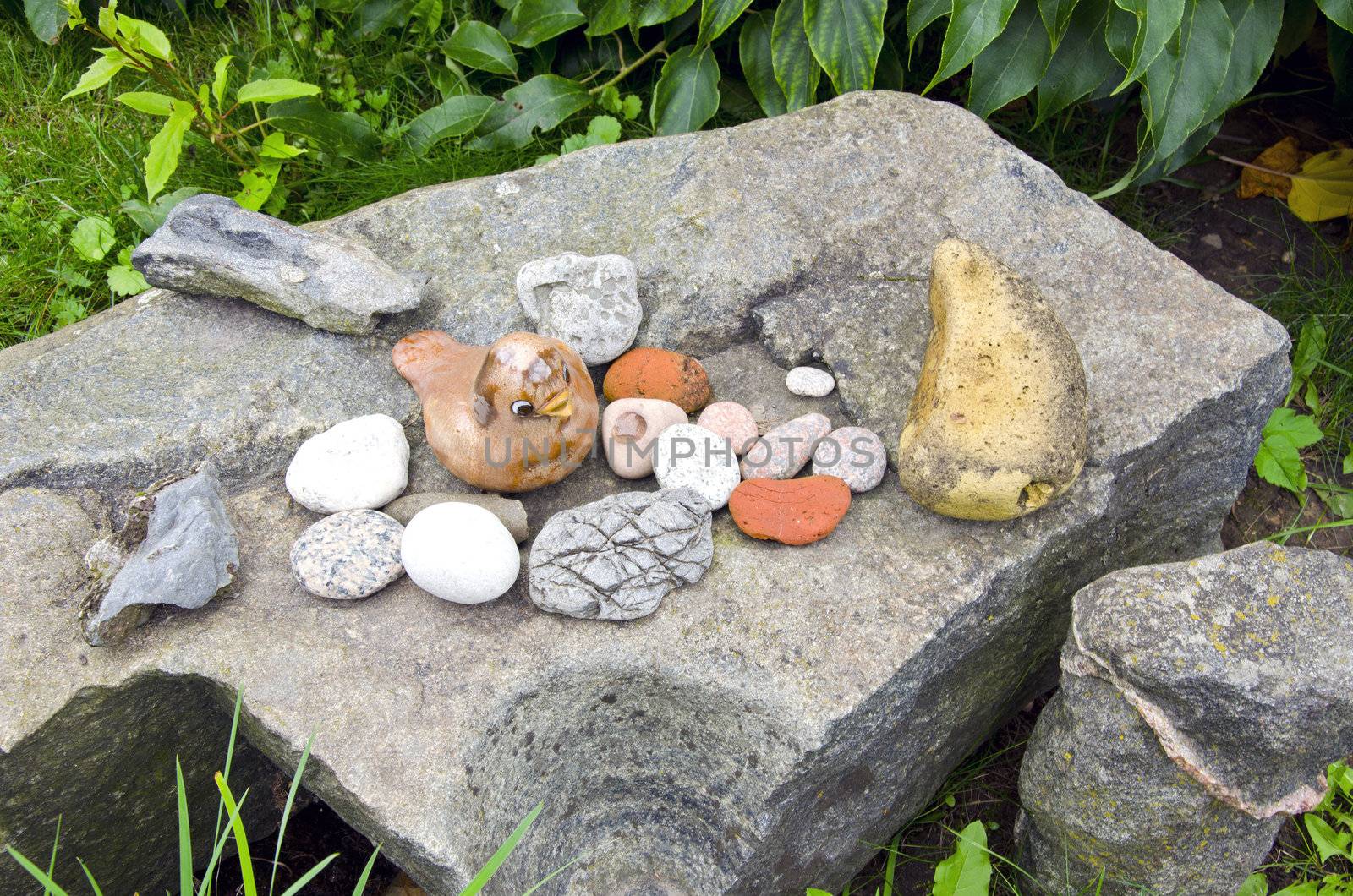 Ancient vintage retro rock stone in garden and decorative objects figure of bird.