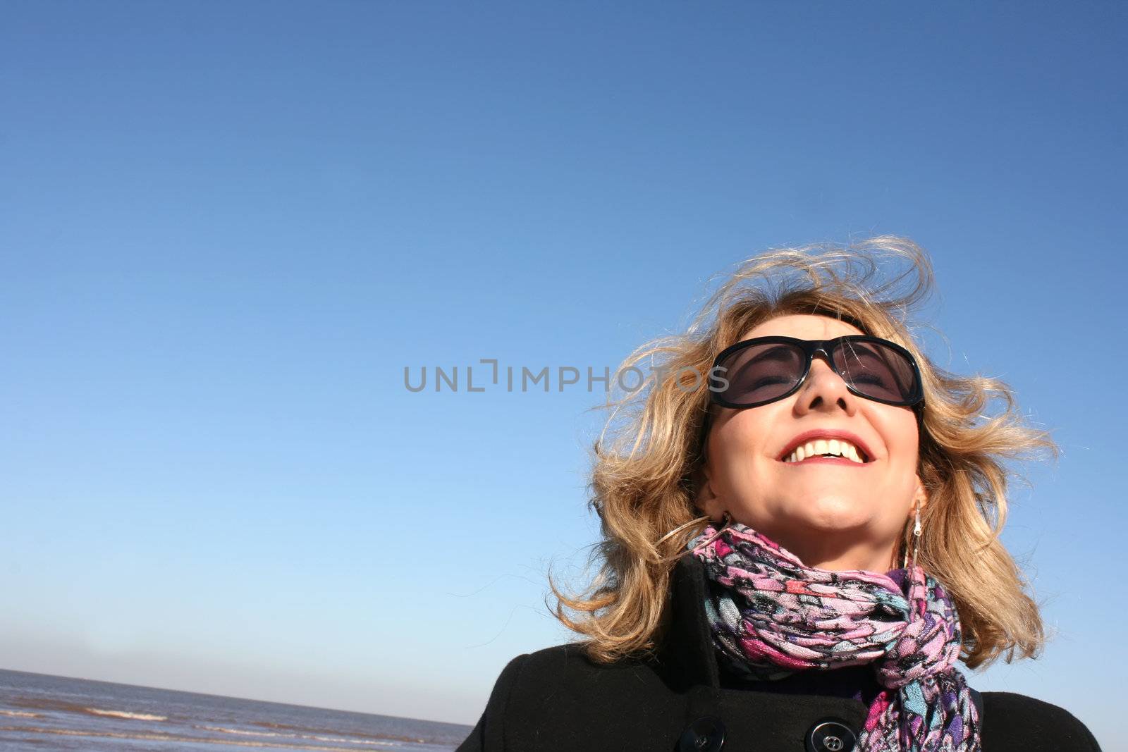 Portrait of a woman enjoying the sunlight on a beach.