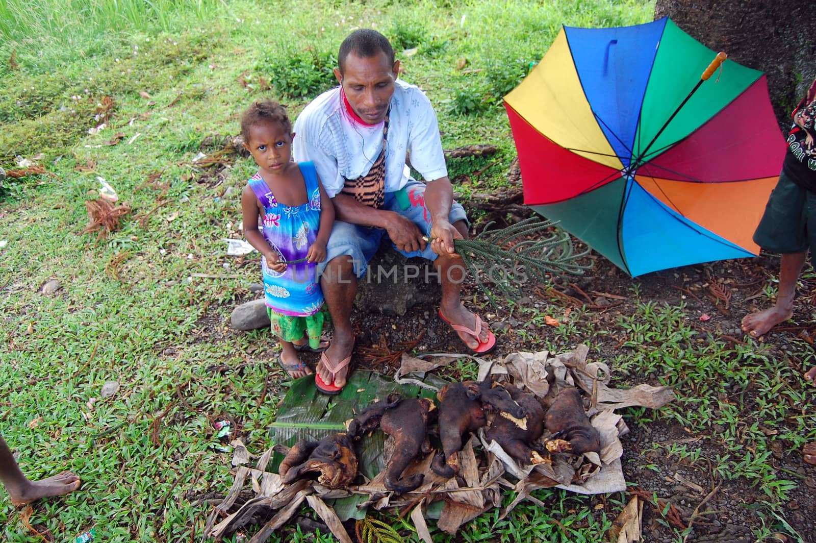 Man ang girl saling pork on market, village in Papua New Guinea