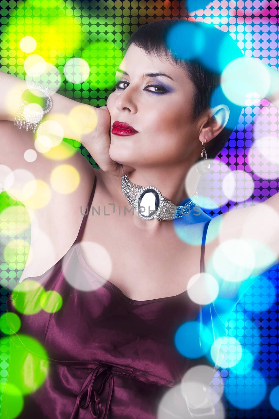 Attractive woman dancing in nightclub, colored background