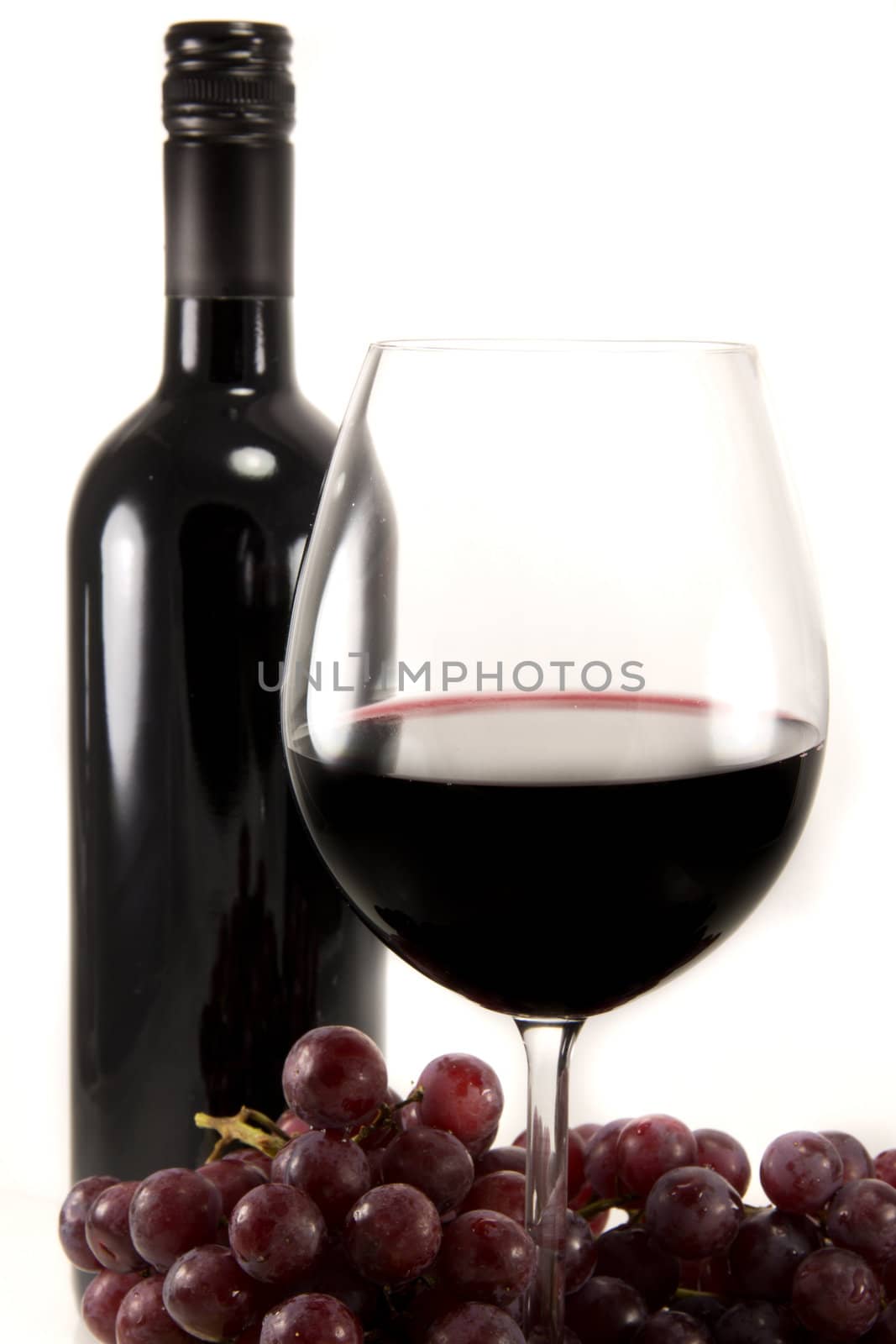 Picture of a bottle of red wine, and a few grapes