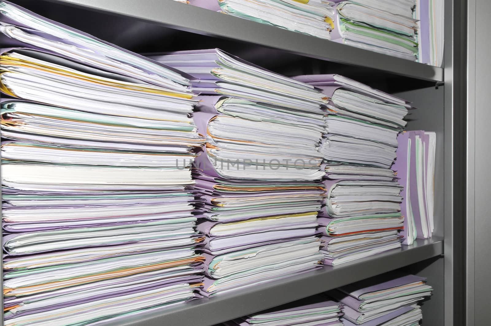 Some stacks of paper folders in a cupboard