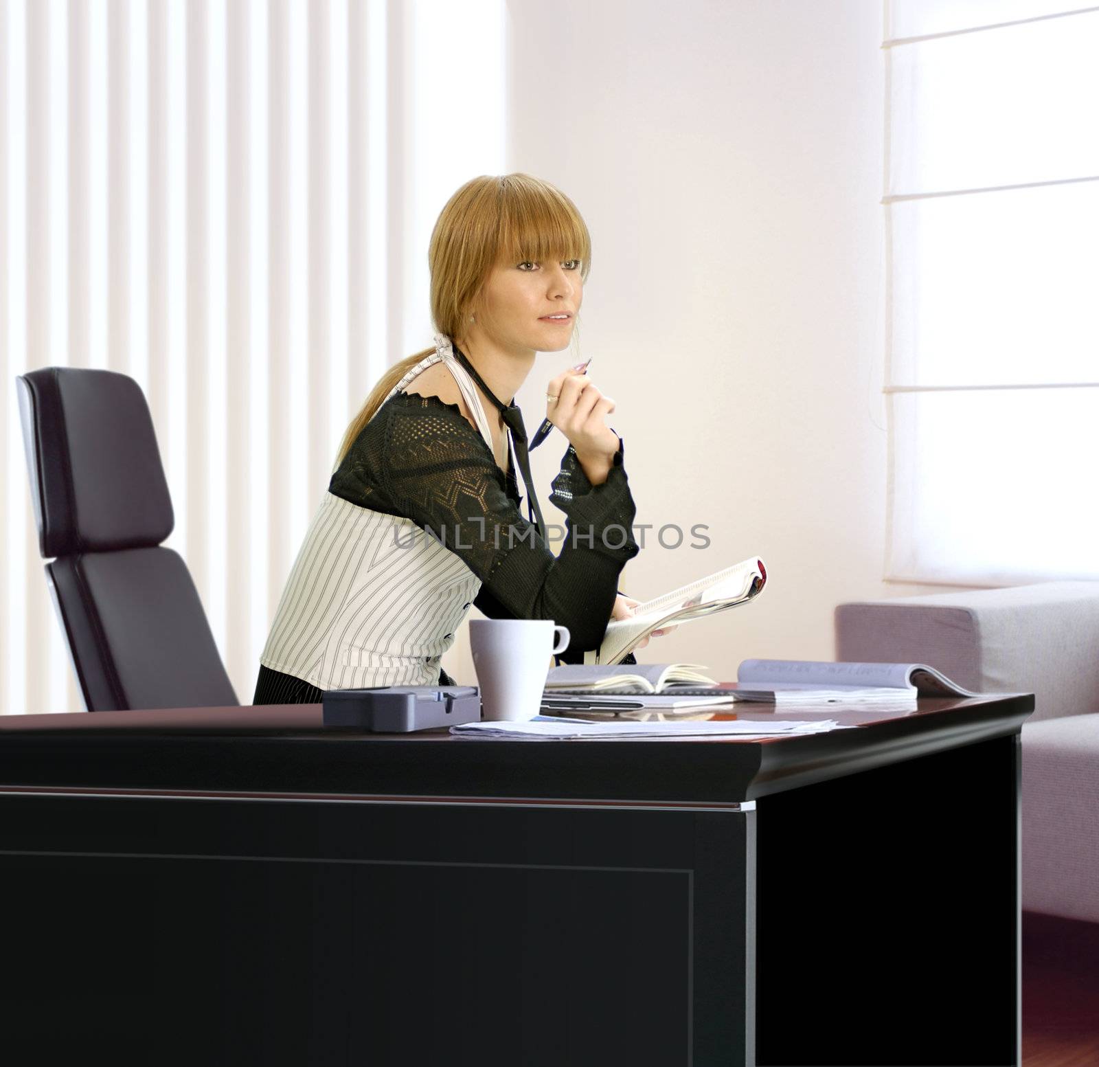Beautiful young blonde businesswoman in her office