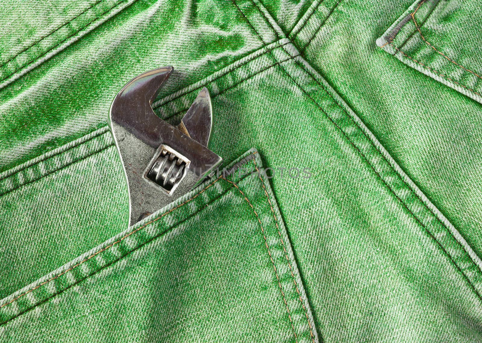 Green jeans pocket with old tool