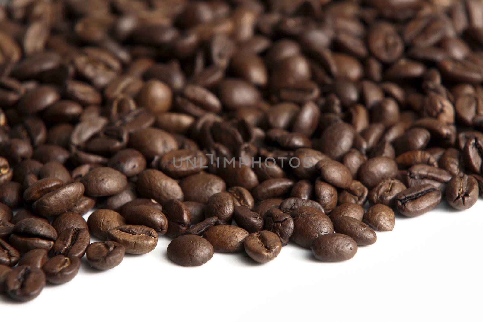 Roasted coffee beans on white background. Shallow depth of field