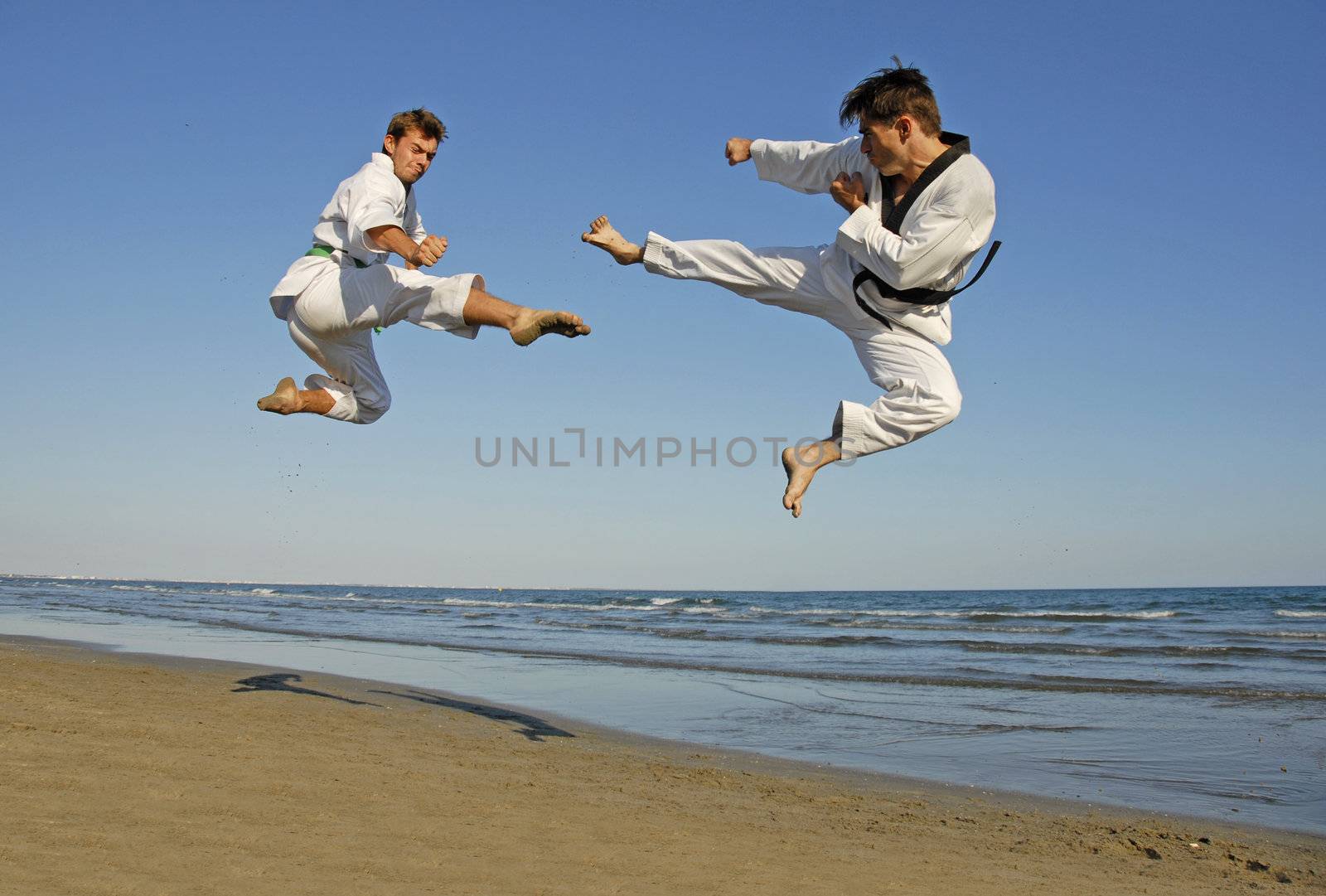 training of the two young men on the beach: taekwondo, martial sport