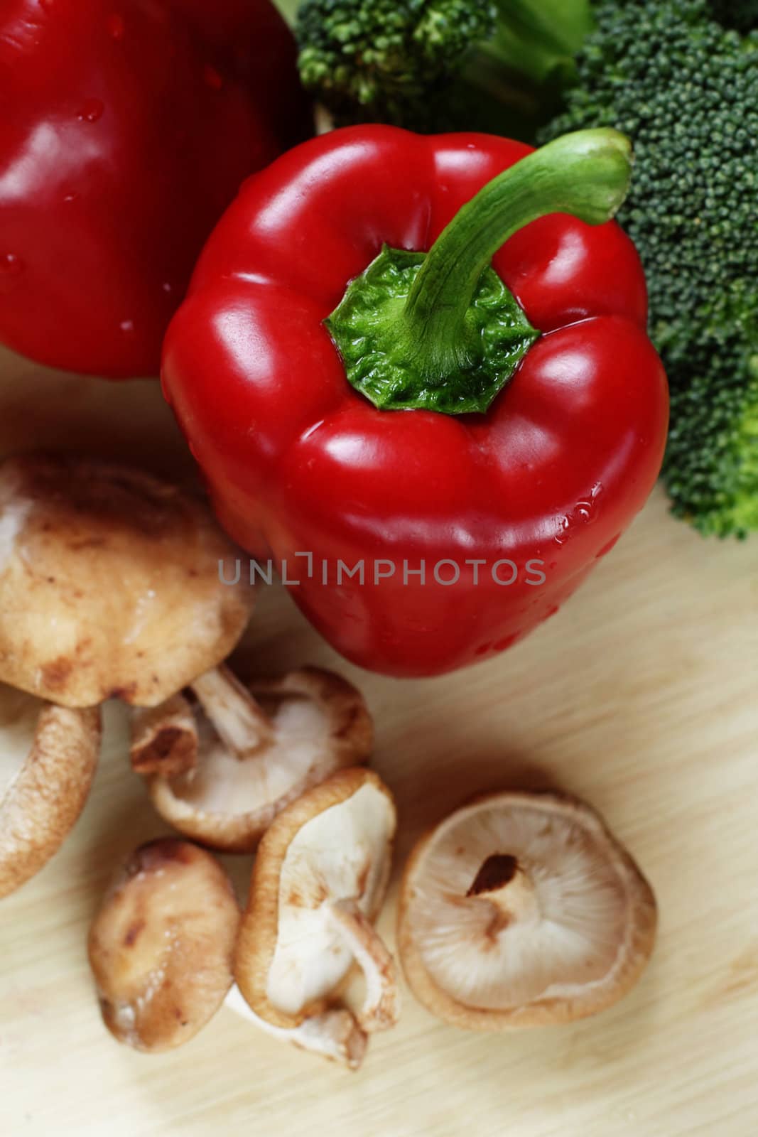 Vegetables on a kitchen table: red pepper, broccoli and shiitake mushrooms