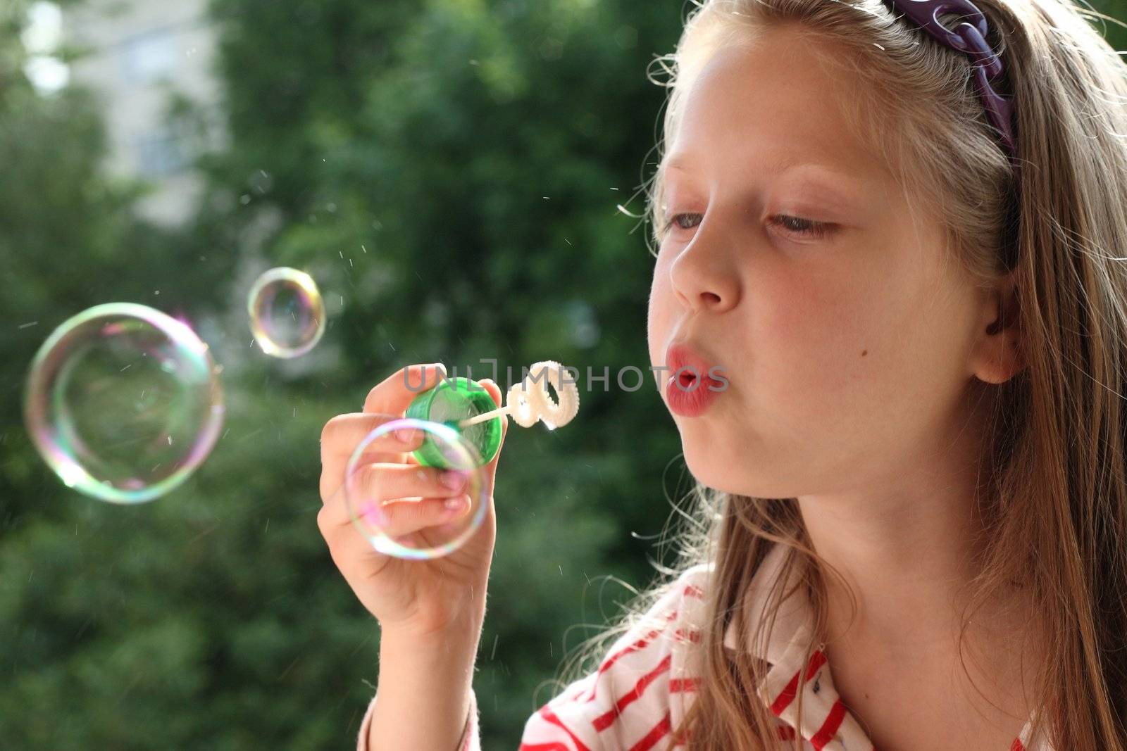 An image of a nice little girl making bubbles