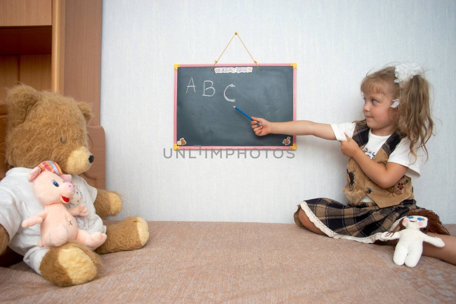 An image of girl with toys and school alackboard