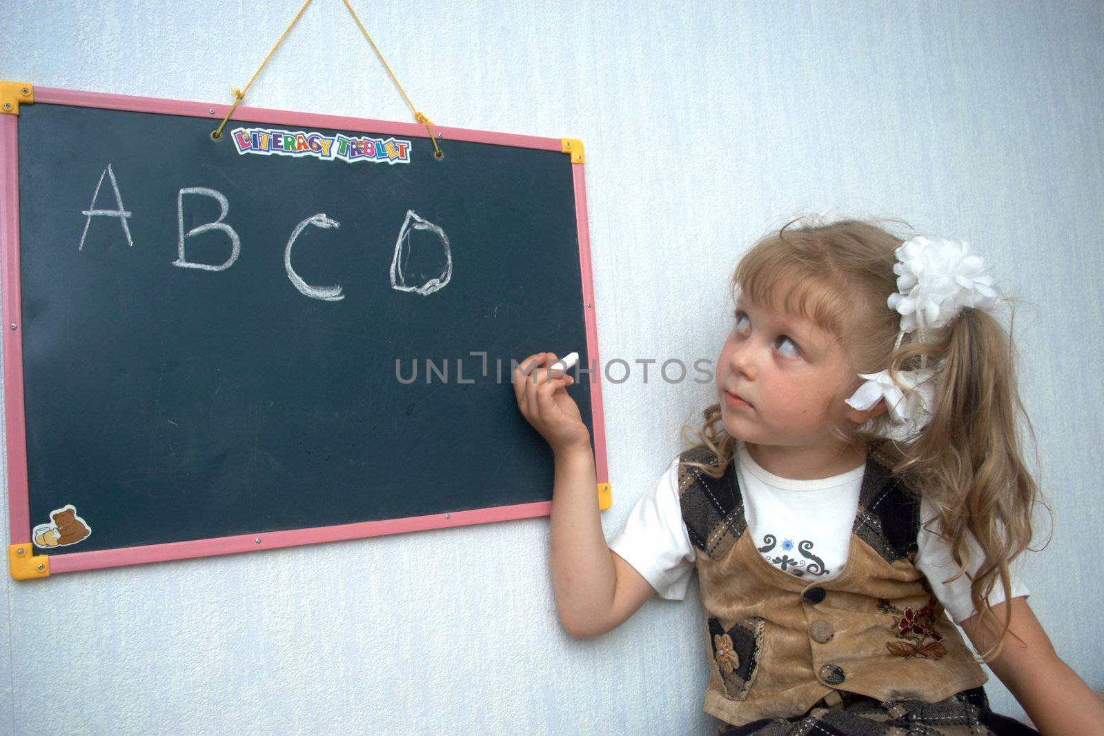 A girl writing letters with chalk