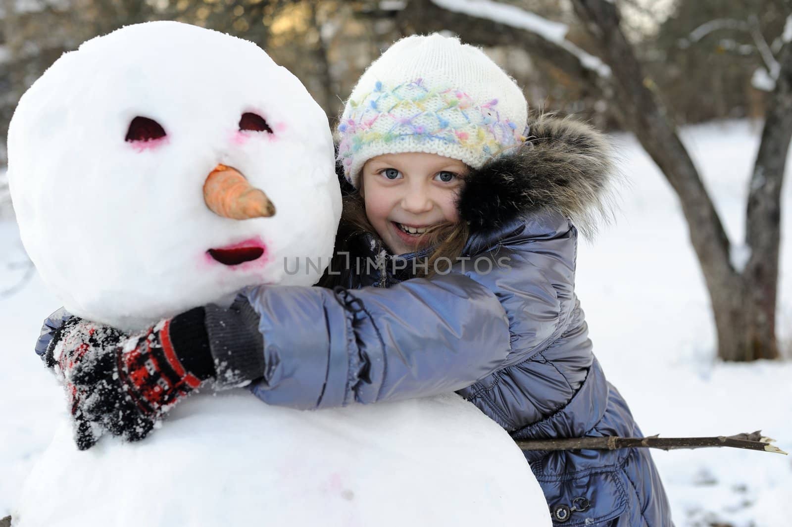 An portraits of happy girl posing with snowman