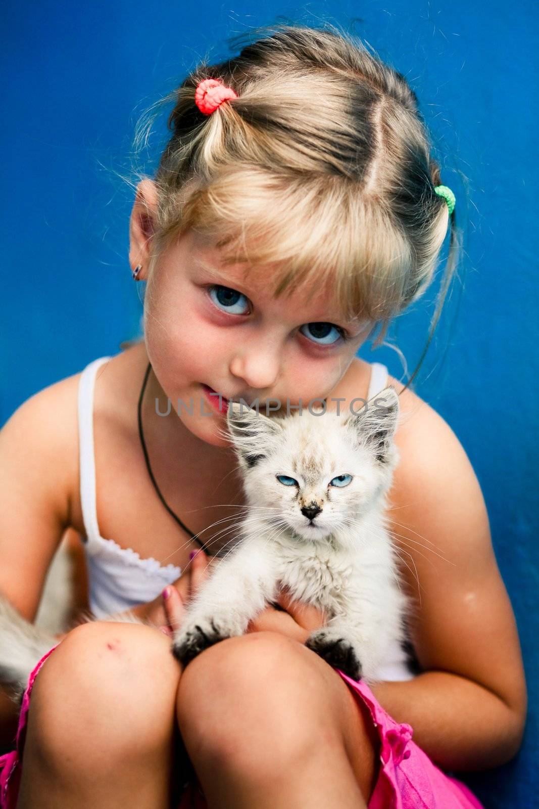 Smiling girl with a small kitten in her arms