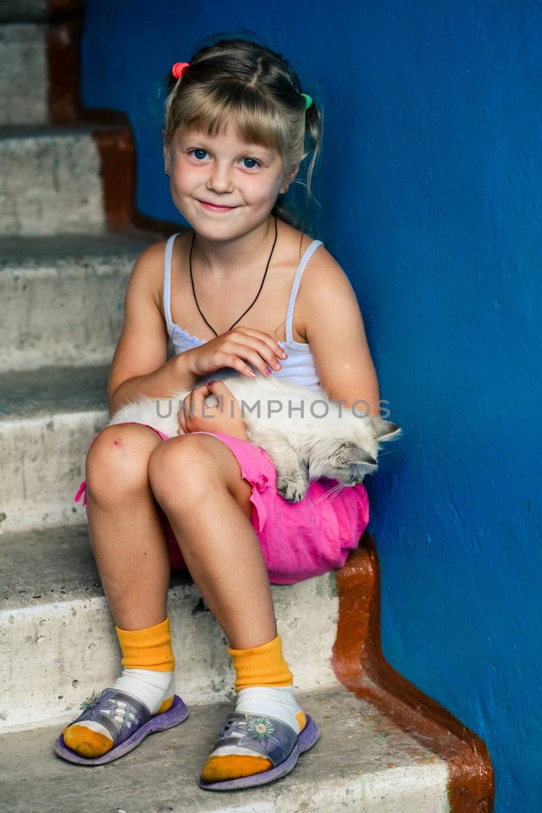 An image of smiling girl with a kitten in her arms