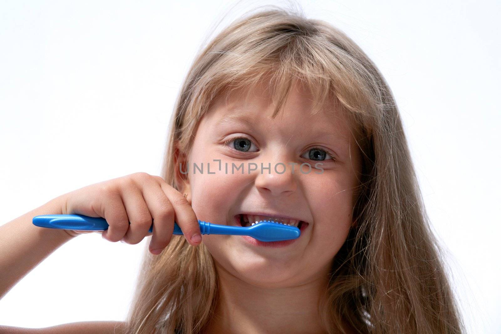 Little girl with toothbrush on neutral background