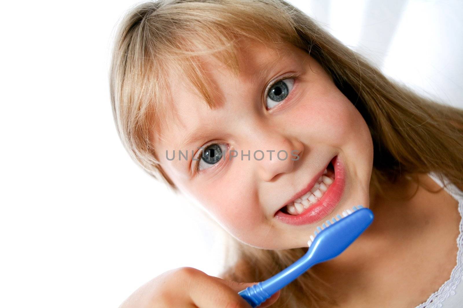 An image of little girl with toothbrush on neutral background